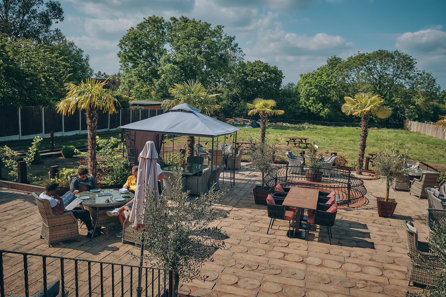 The garden at The Mesken: palms, the pergola and the field beyond